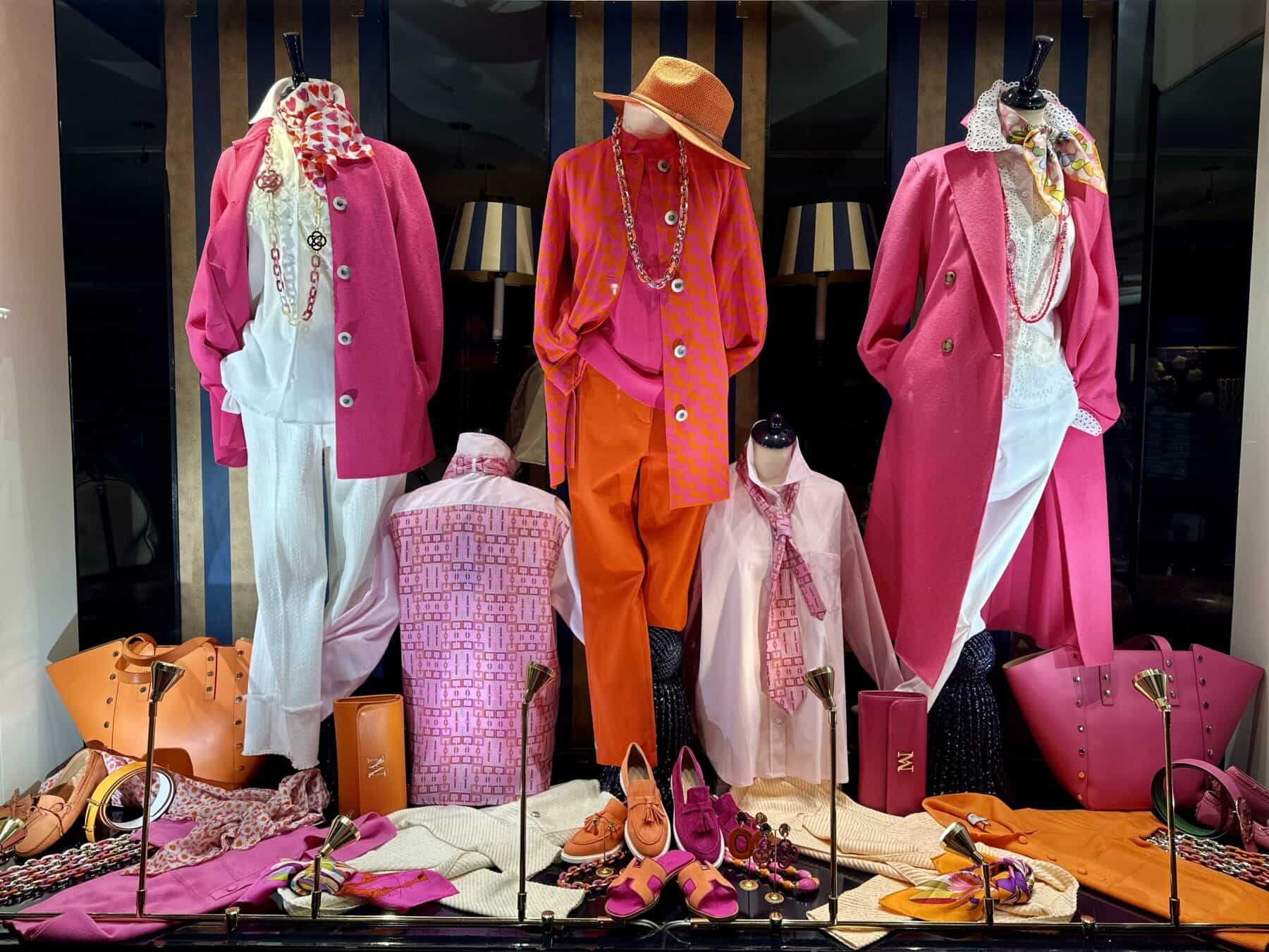 Modici display met kleurrijke dameskleding en accessoires in een winkel.