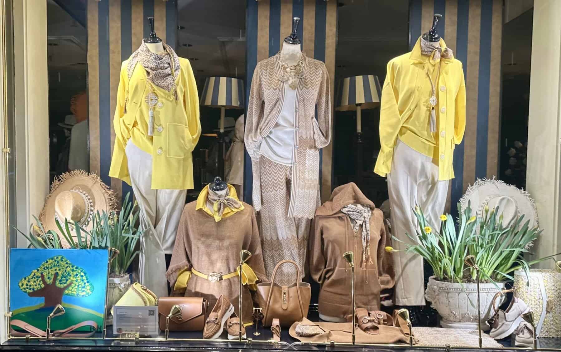 Modici zomeroutfit met oranje en witte accessoires op mannequin.