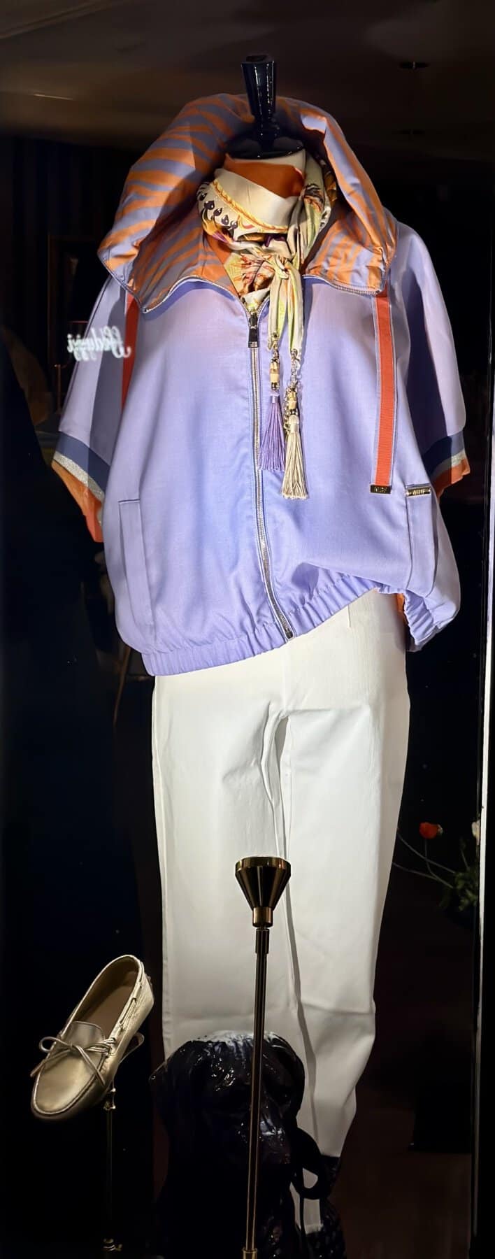 Modici casual sportoutfit met hoodie en witte broek op mannequin.