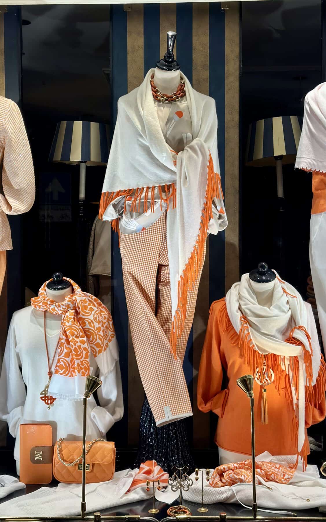 Modici damesmode en accessoires met oranje en wit details.